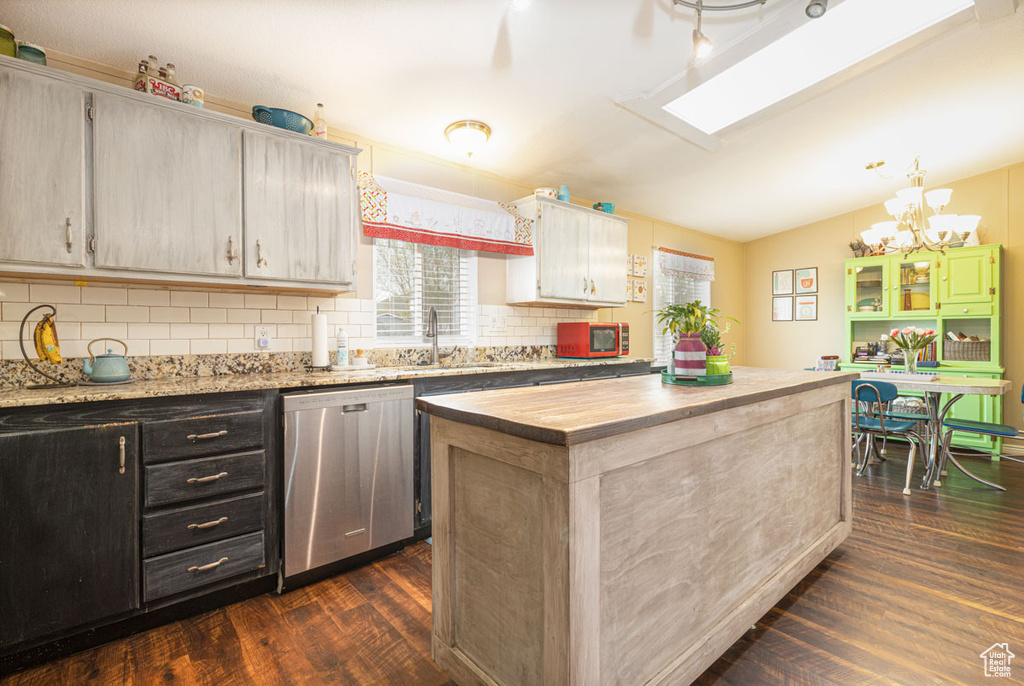 Kitchen with a healthy amount of sunlight, a sink, dark wood-type flooring, and dishwasher