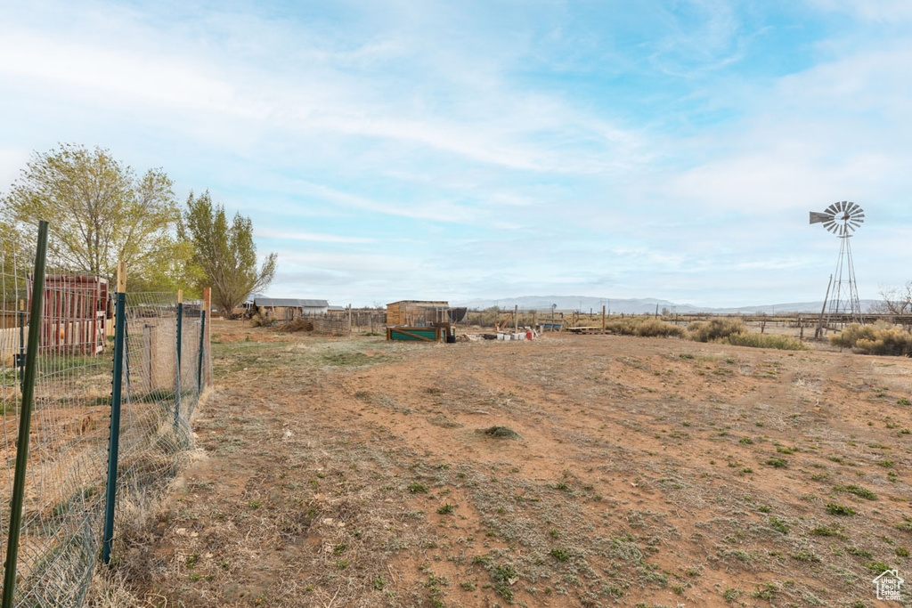 View of yard with a rural view and fence