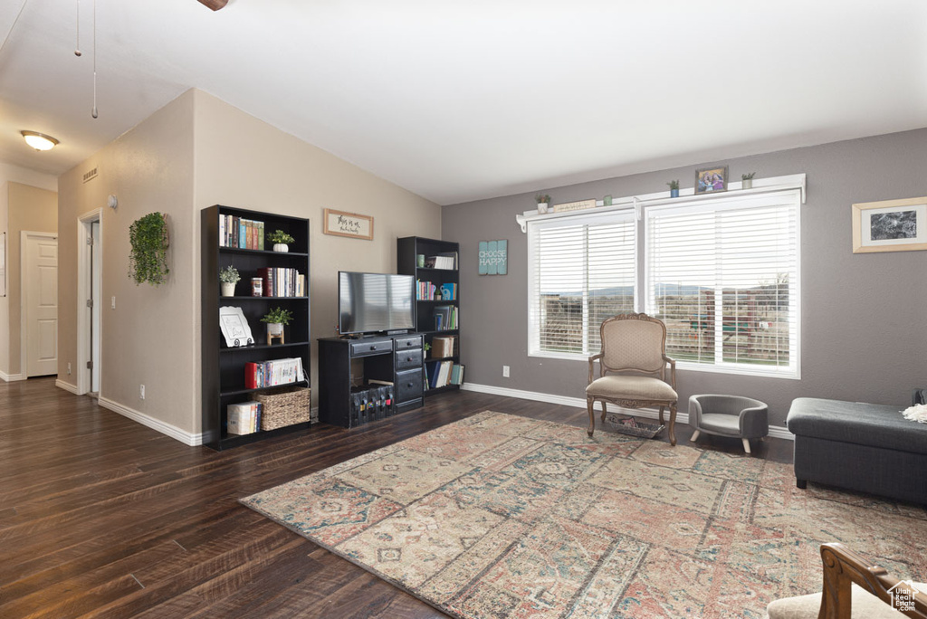 Living area featuring baseboards, lofted ceiling, and wood finished floors