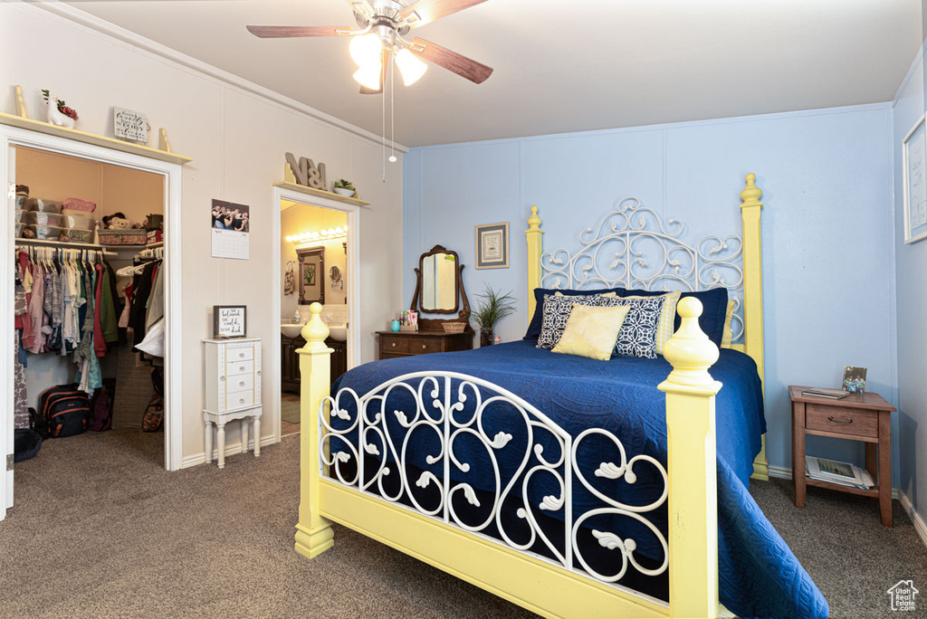 Bedroom with a closet, a ceiling fan, ensuite bathroom, a spacious closet, and carpet flooring