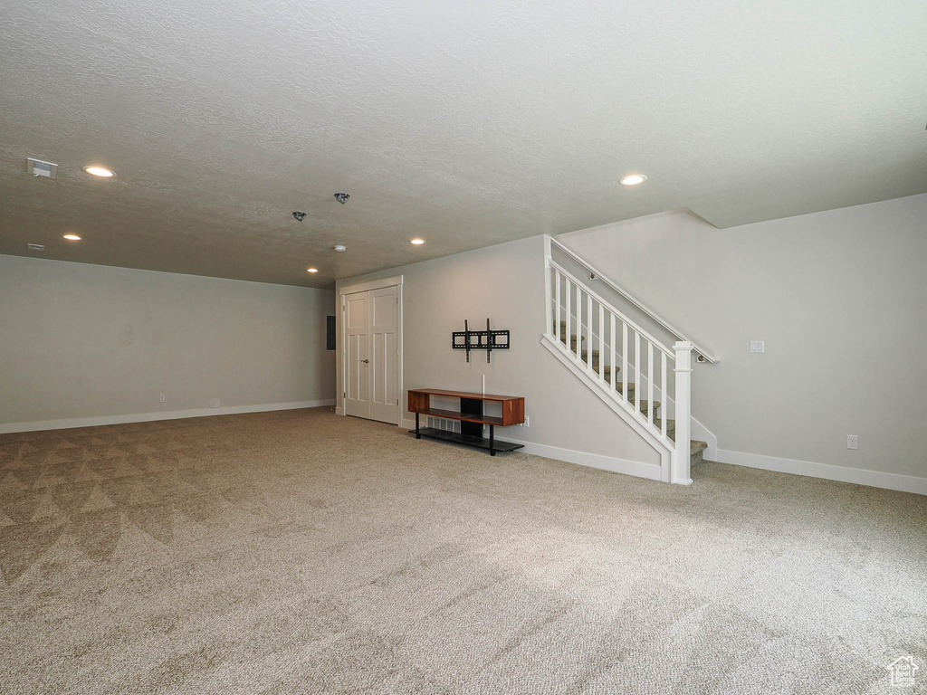 Interior space with light colored carpet, recessed lighting, baseboards, and stairway