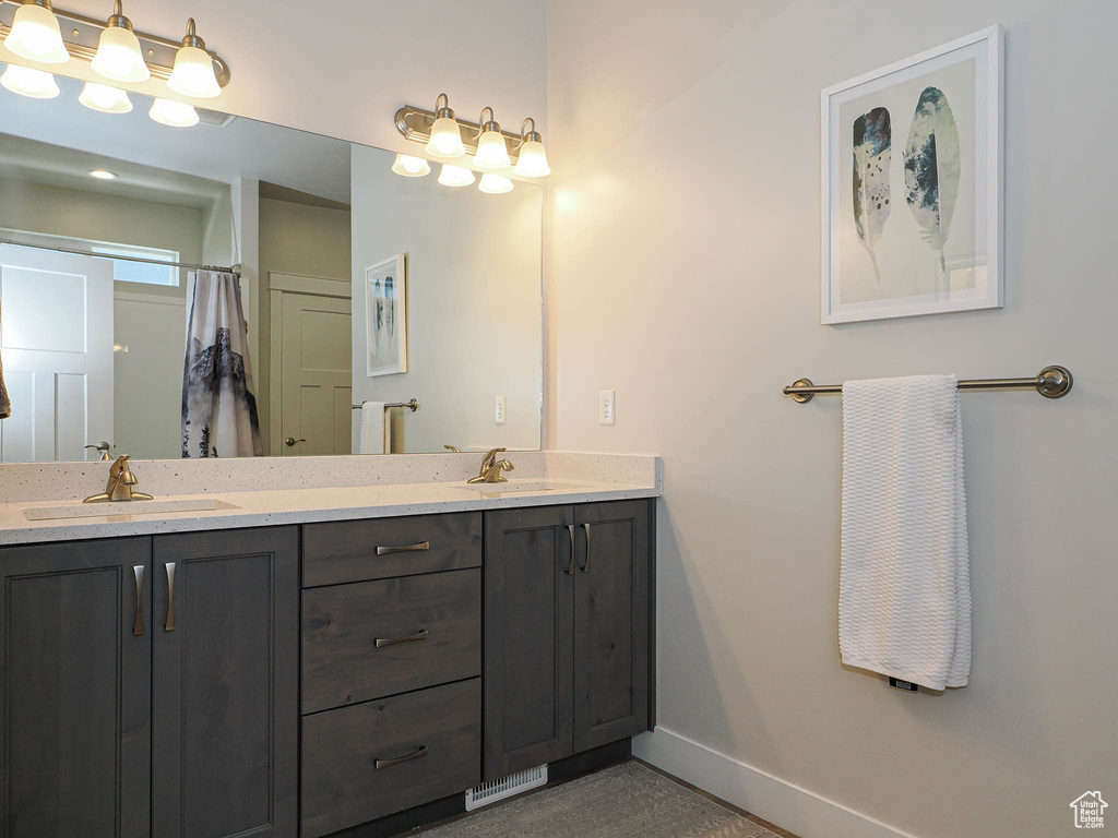 Bathroom with baseboards, a sink, and double vanity