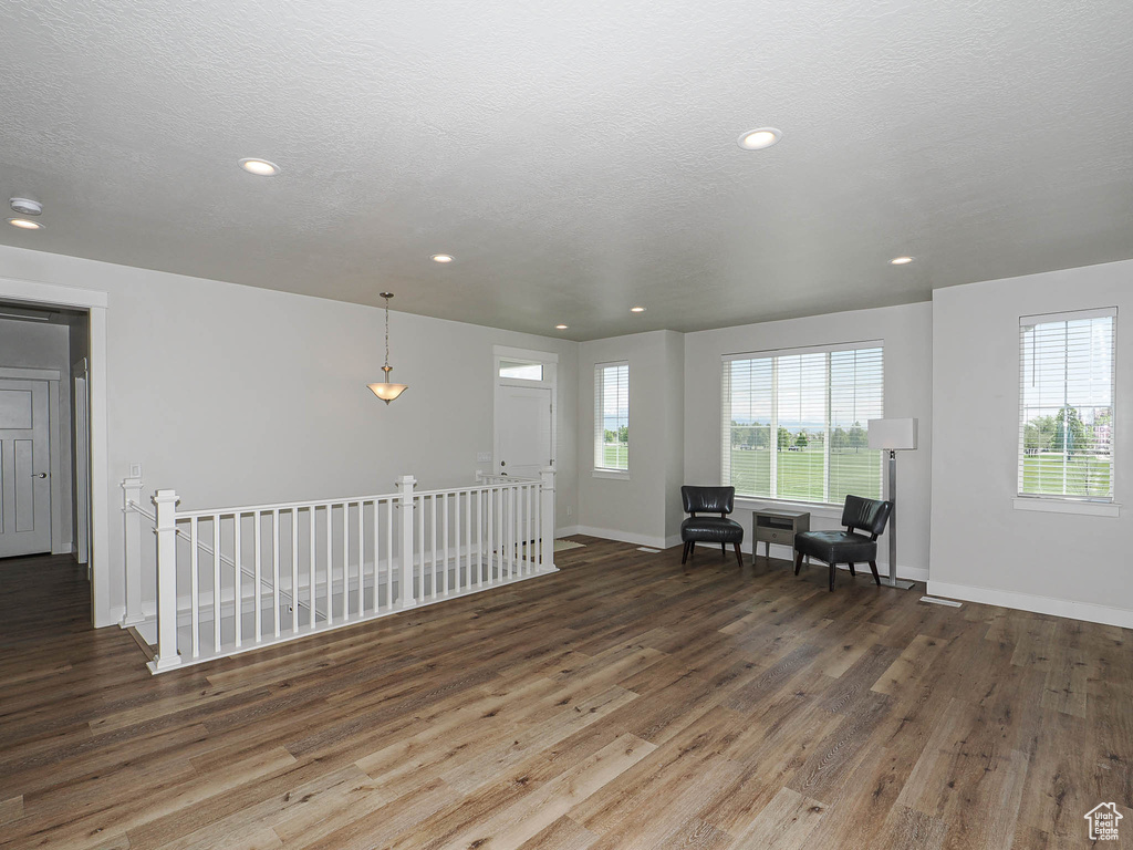 Living area with baseboards, recessed lighting, wood finished floors, and an upstairs landing
