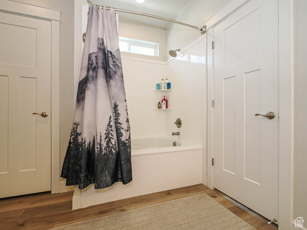 Bathroom featuring shower / bath combo with shower curtain and wood finished floors