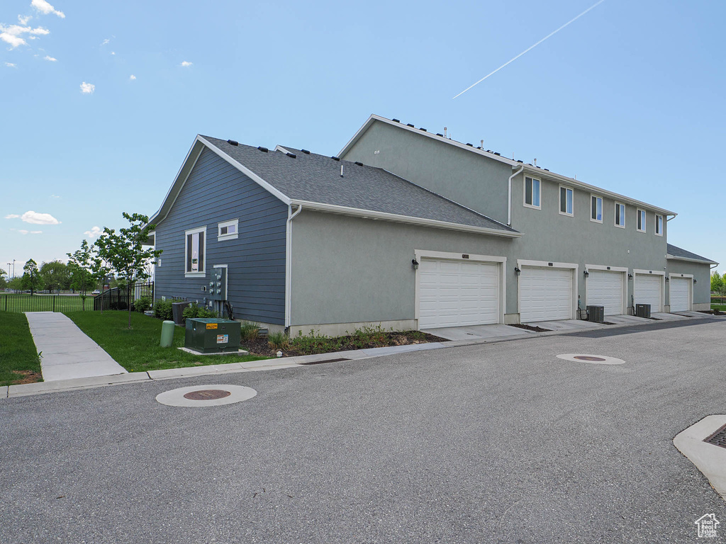 View of home's exterior with stucco siding, a lawn, and fence