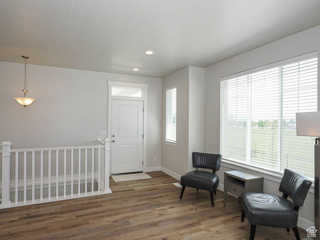 Living area with baseboards, recessed lighting, wood finished floors, and an upstairs landing