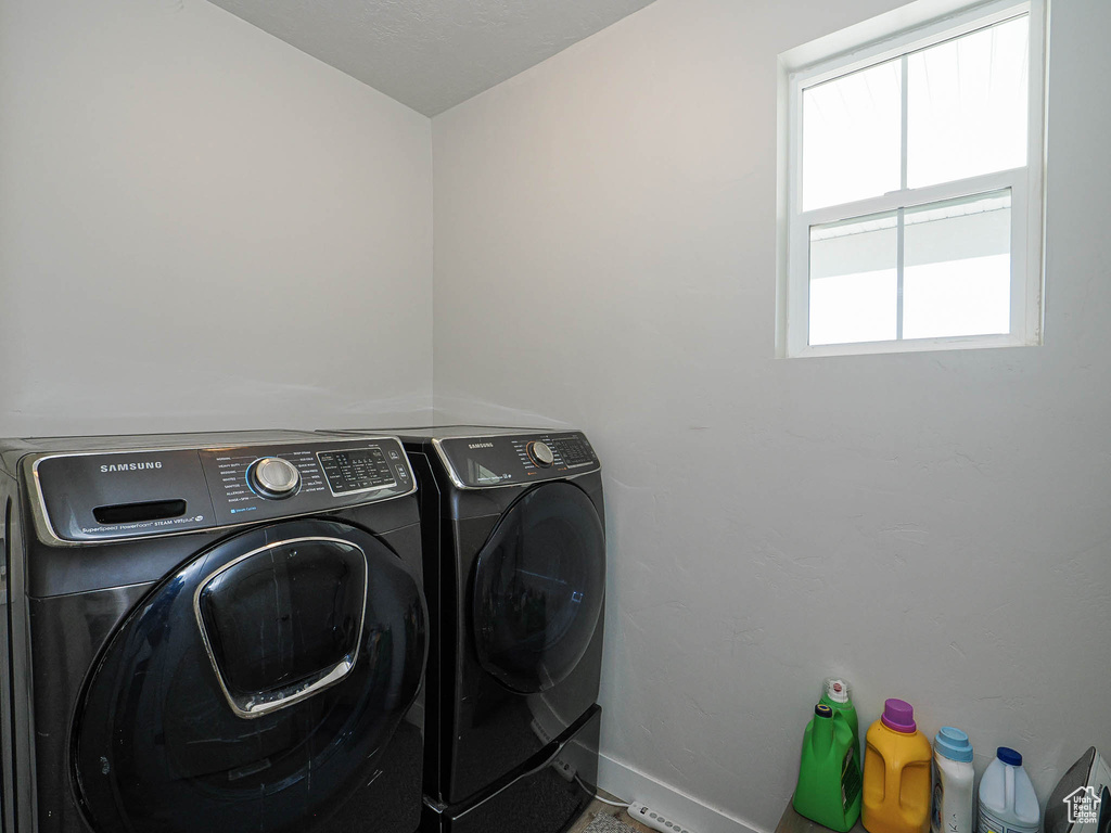 Laundry room featuring laundry area, baseboards, and washer and dryer