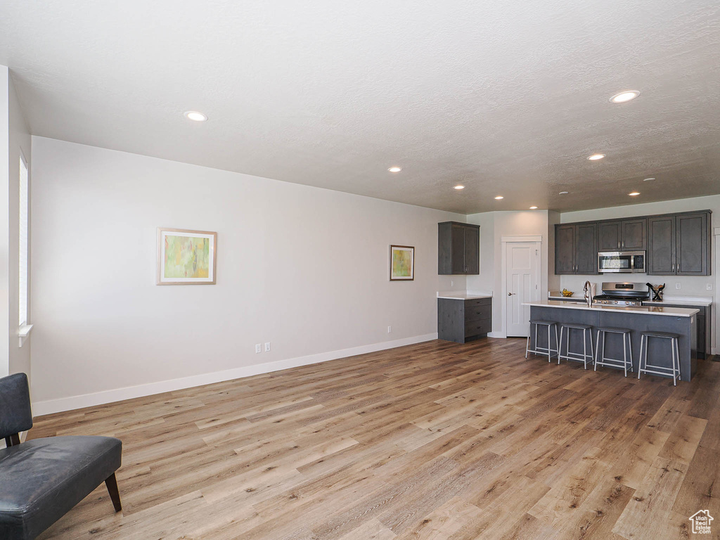 Living area featuring recessed lighting, baseboards, and light wood finished floors