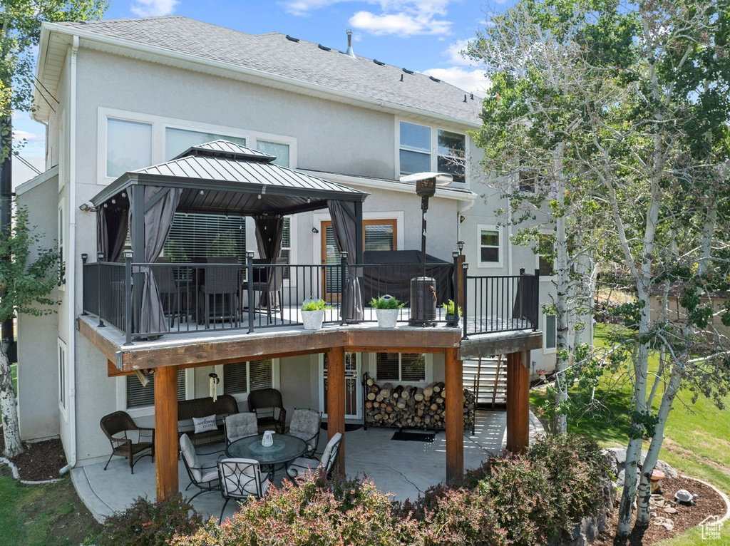 Rear view of property featuring a patio, a gazebo, an outdoor living space, and stucco siding