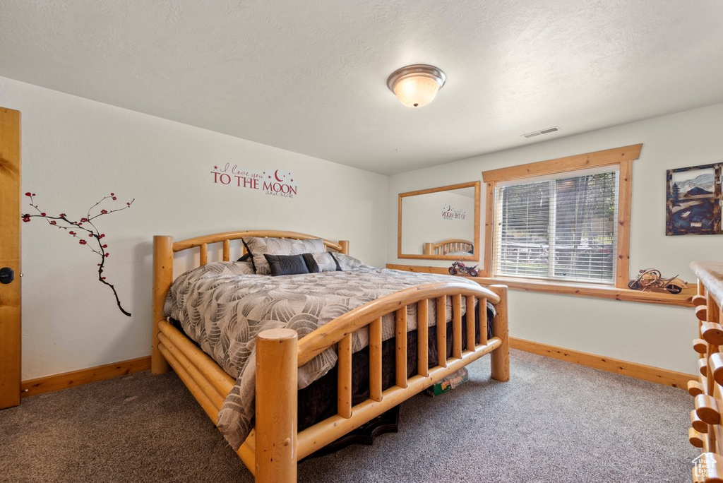 Bedroom featuring baseboards, visible vents, and carpet