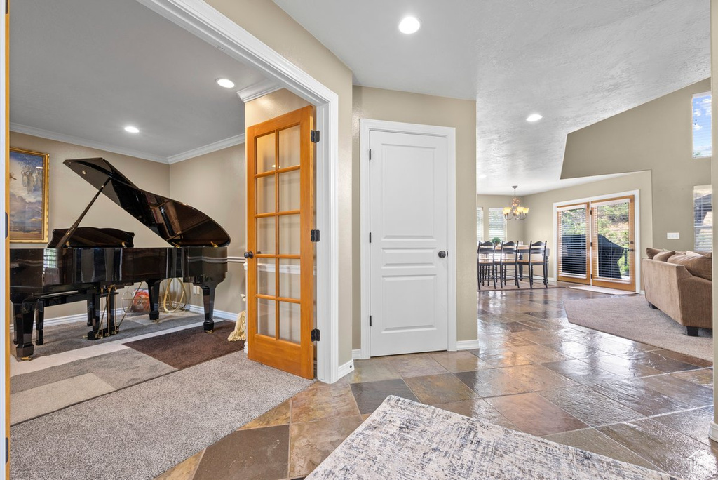 Foyer with stone tile flooring, recessed lighting, baseboards, and a chandelier