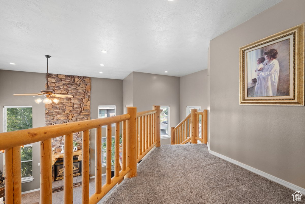 Hall featuring baseboards, plenty of natural light, carpet, and an upstairs landing