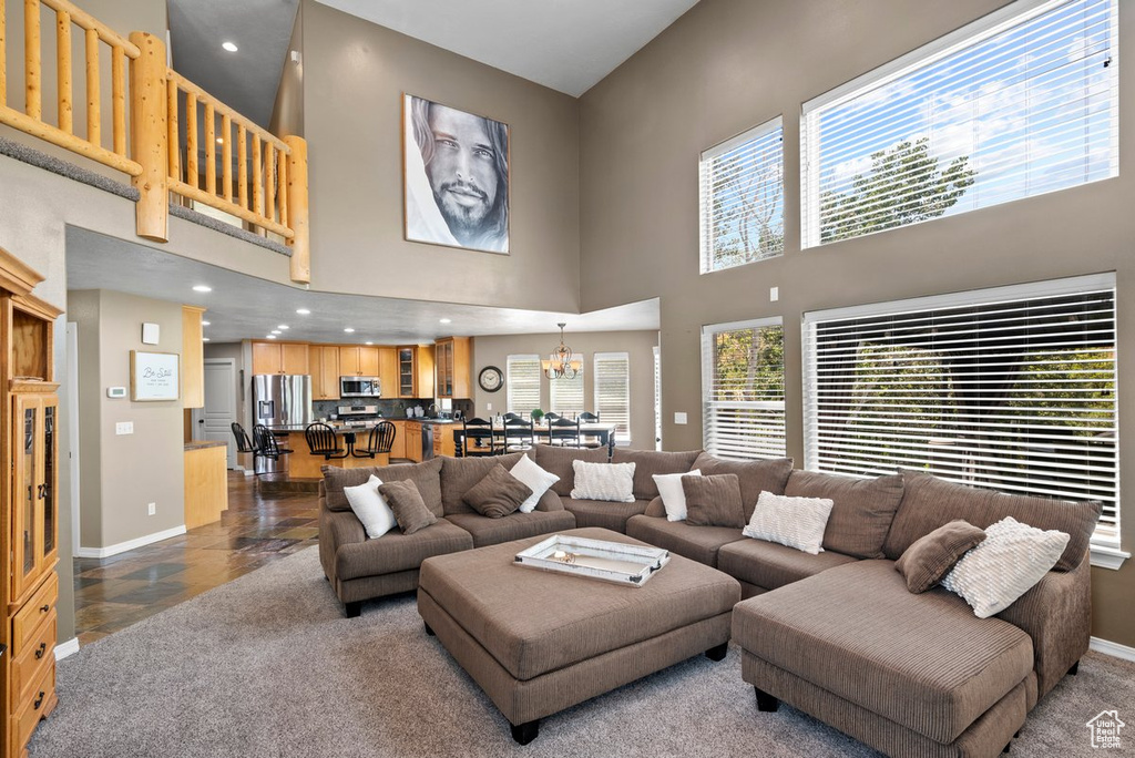 Living area featuring an inviting chandelier, baseboards, and a towering ceiling