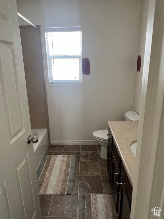 Full bathroom with vanity, baseboards, shower / bath combination, and toilet