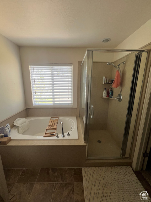 Bathroom featuring a shower stall and a bath