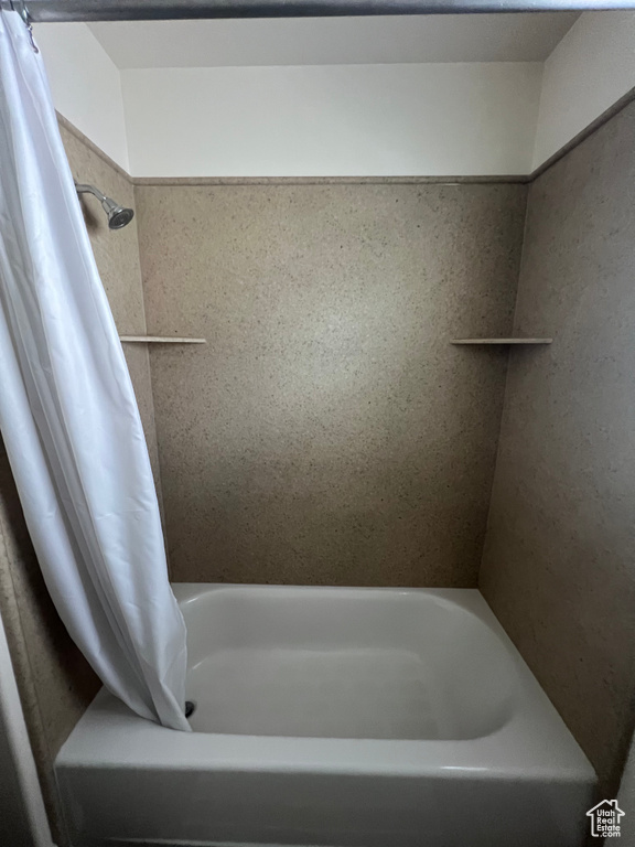 Bathroom with a shower with curtain and a tub to relax in