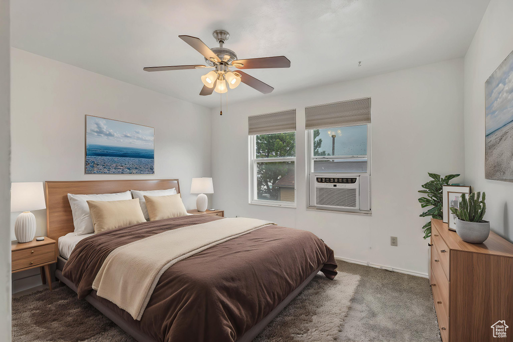 Carpeted bedroom featuring baseboards, ceiling fan, and cooling unit