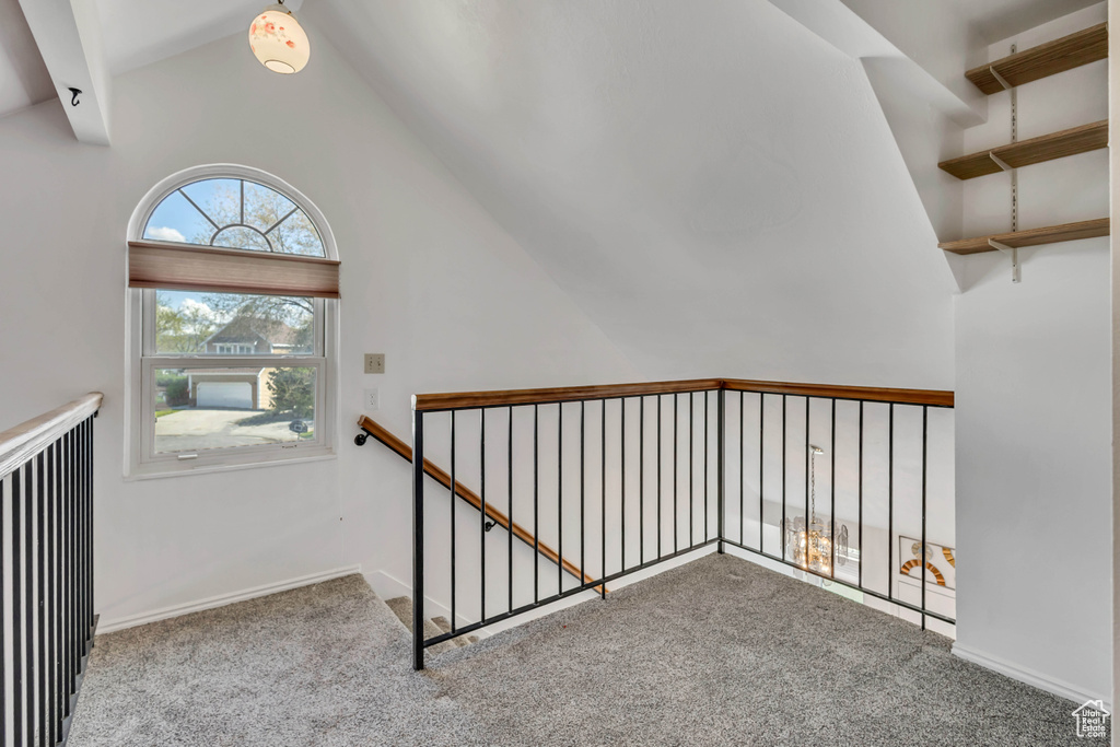 Stairway featuring baseboards, carpet flooring, and high vaulted ceiling