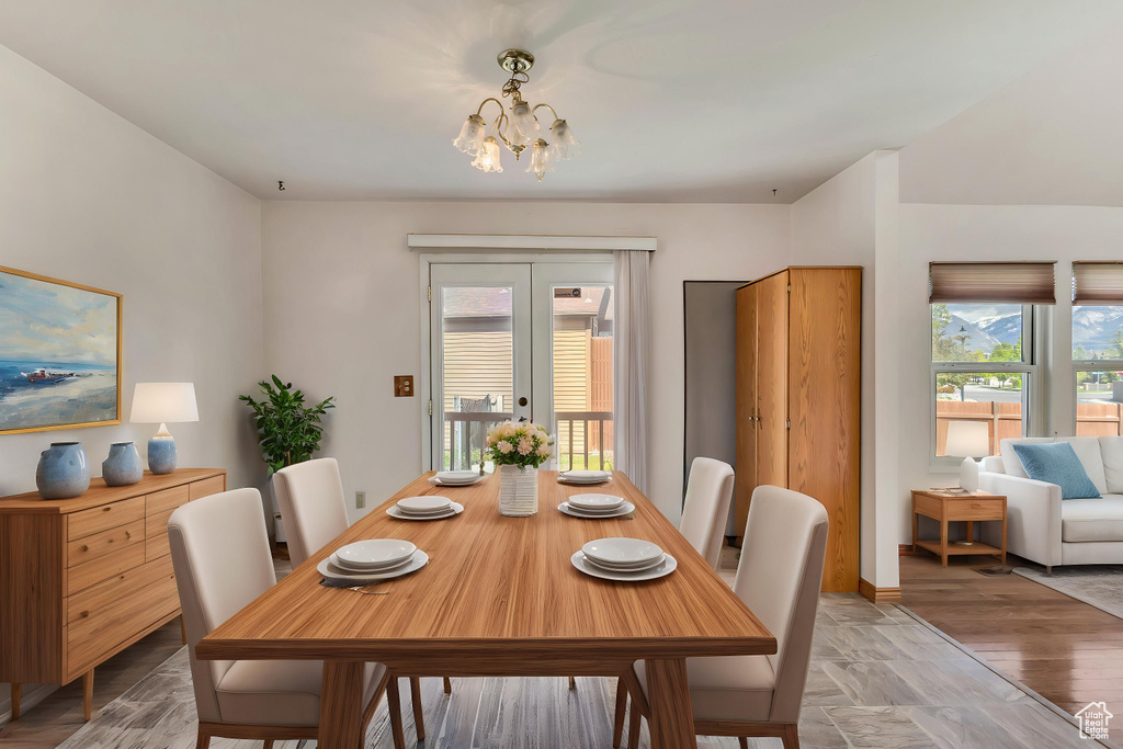 Dining room featuring french doors, baseboards, and a notable chandelier