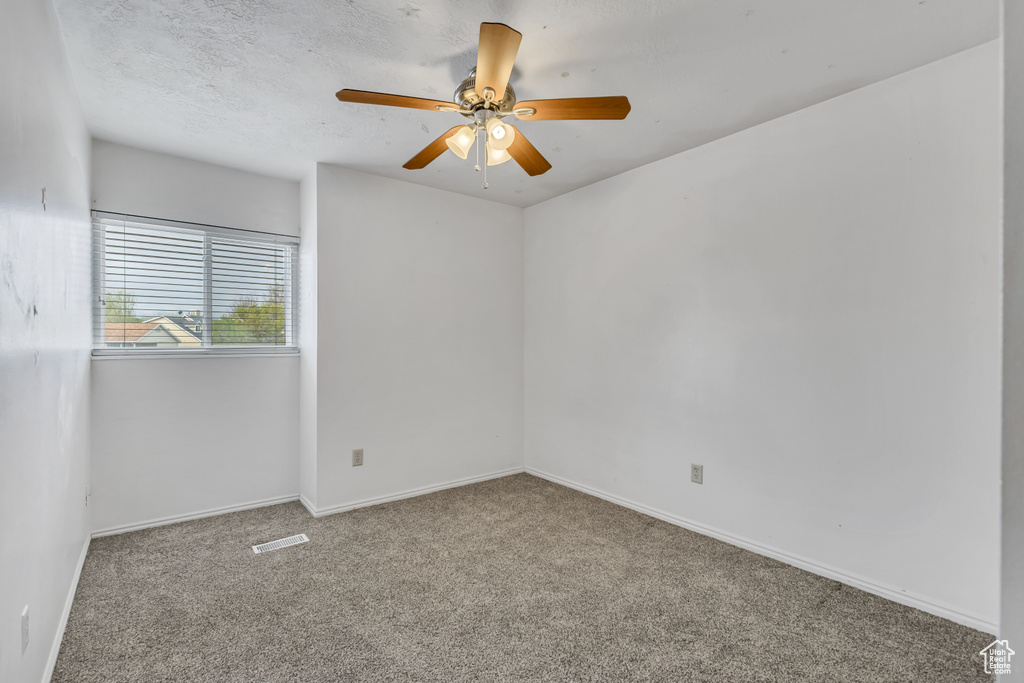 Empty room with baseboards, ceiling fan, carpet flooring, and visible vents