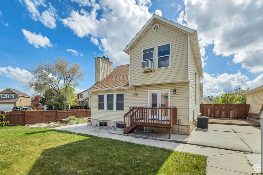 Back of house with french doors, a fenced backyard, a lawn, and a patio area