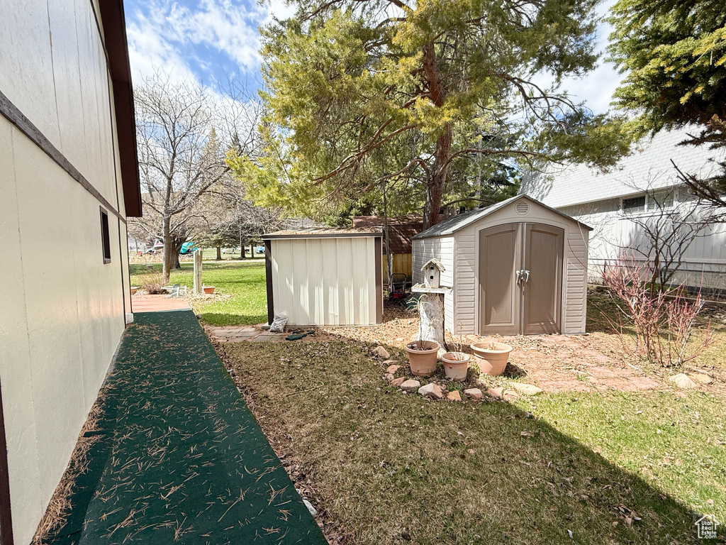 View of yard featuring an outdoor structure and a storage unit