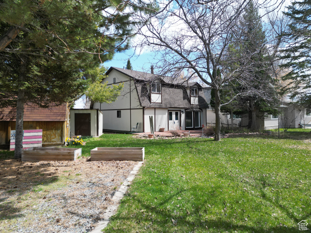 View of front facade with roof with shingles and a front yard