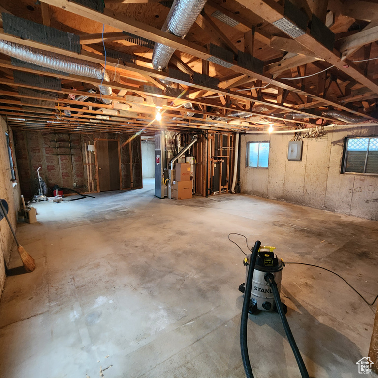 Below grade area featuring heating unit and electric panel