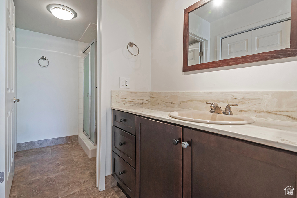 Full bath with a shower stall and vanity