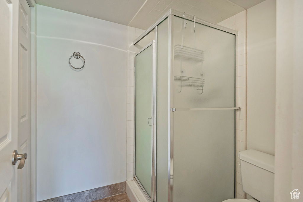 Bathroom with a shower stall and toilet