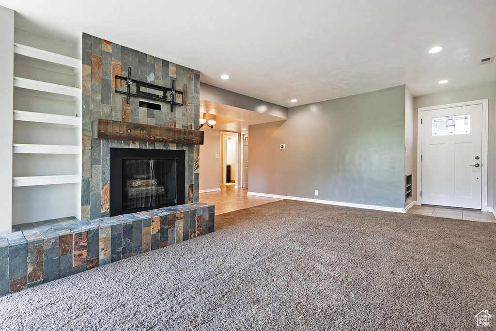 Unfurnished living room featuring baseboards, carpet, recessed lighting, and a large fireplace