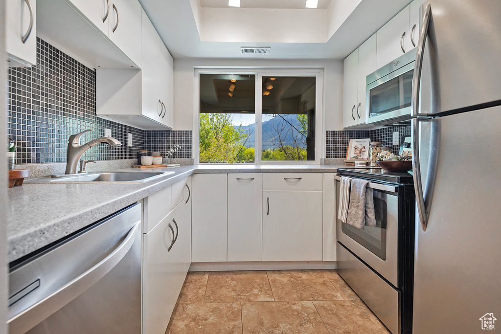 Kitchen with visible vents, light countertops, tasteful backsplash, a sink, and appliances with stainless steel finishes