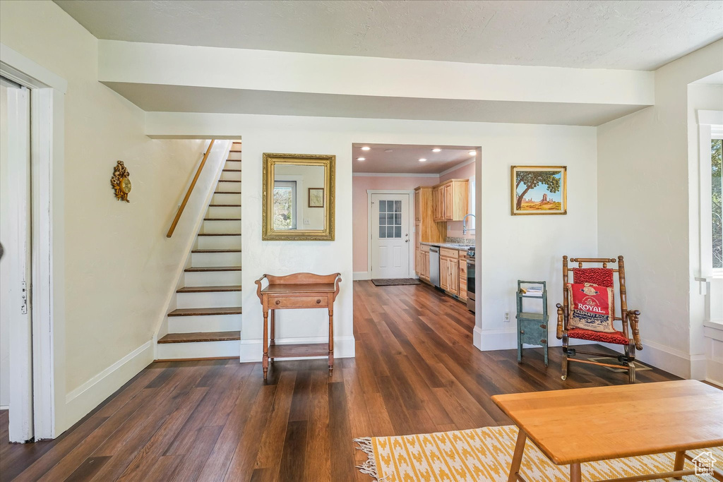 Living area featuring baseboards, recessed lighting, stairs, and dark wood-type flooring