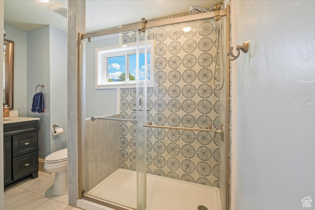 Full bathroom with vanity, toilet, tile patterned floors, and a stall shower