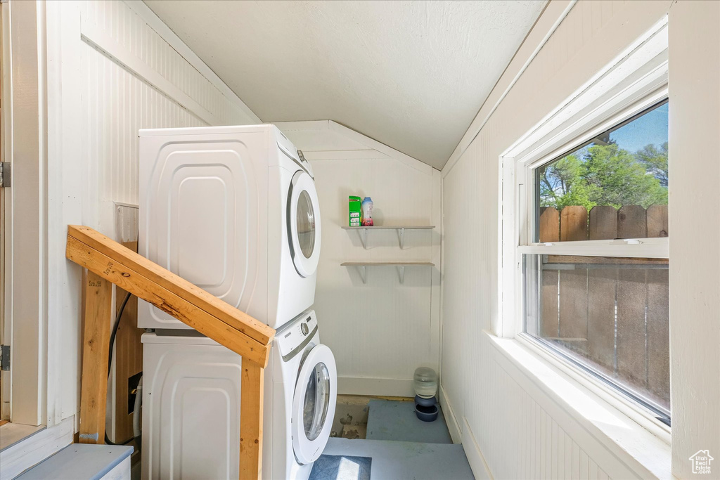 Laundry room with stacked washer and dryer and laundry area