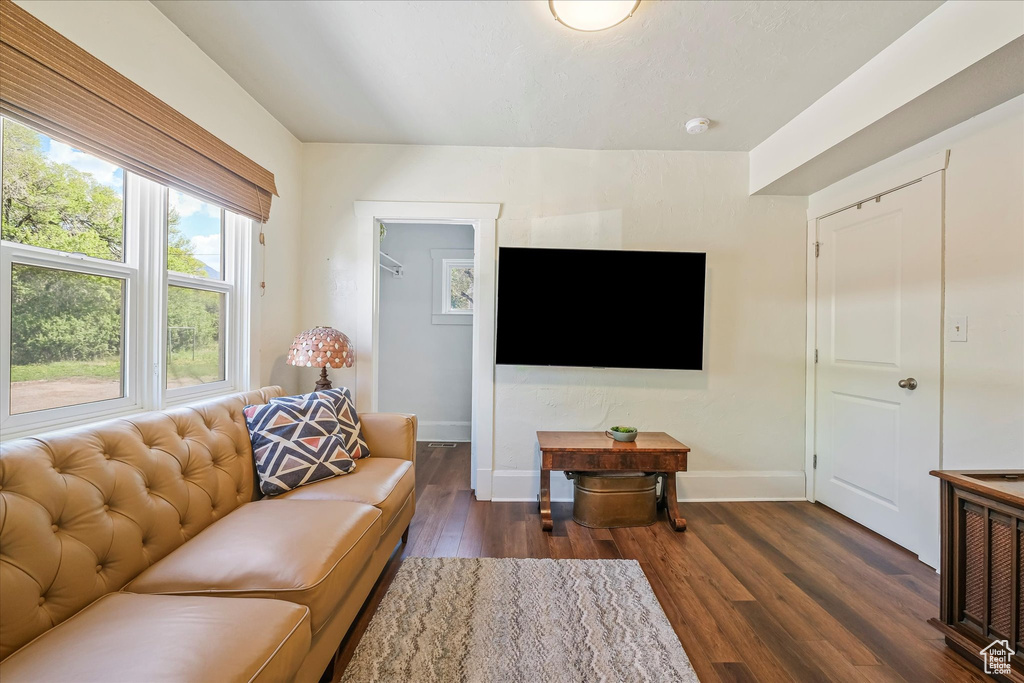 Living area with baseboards and dark wood finished floors