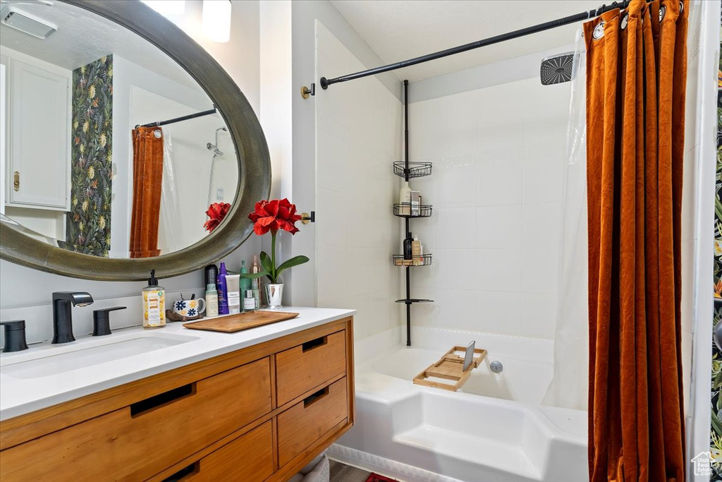 Full bathroom featuring shower / bath combo with shower curtain and vanity