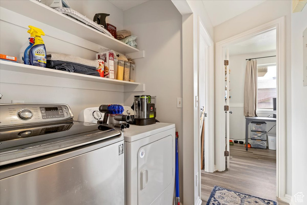 Washroom featuring laundry area, light wood finished floors, and washer and dryer