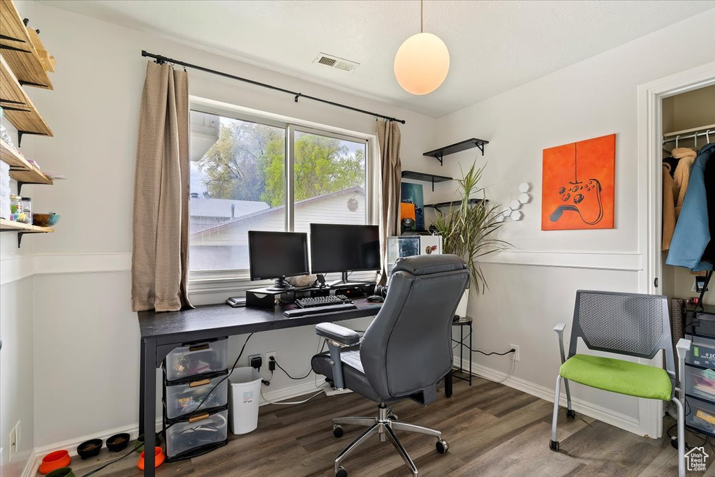 Home office featuring baseboards, wood finished floors, and visible vents