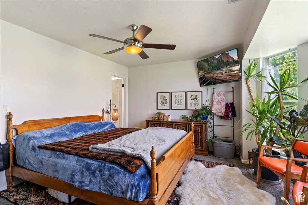 Carpeted bedroom featuring baseboards and ceiling fan