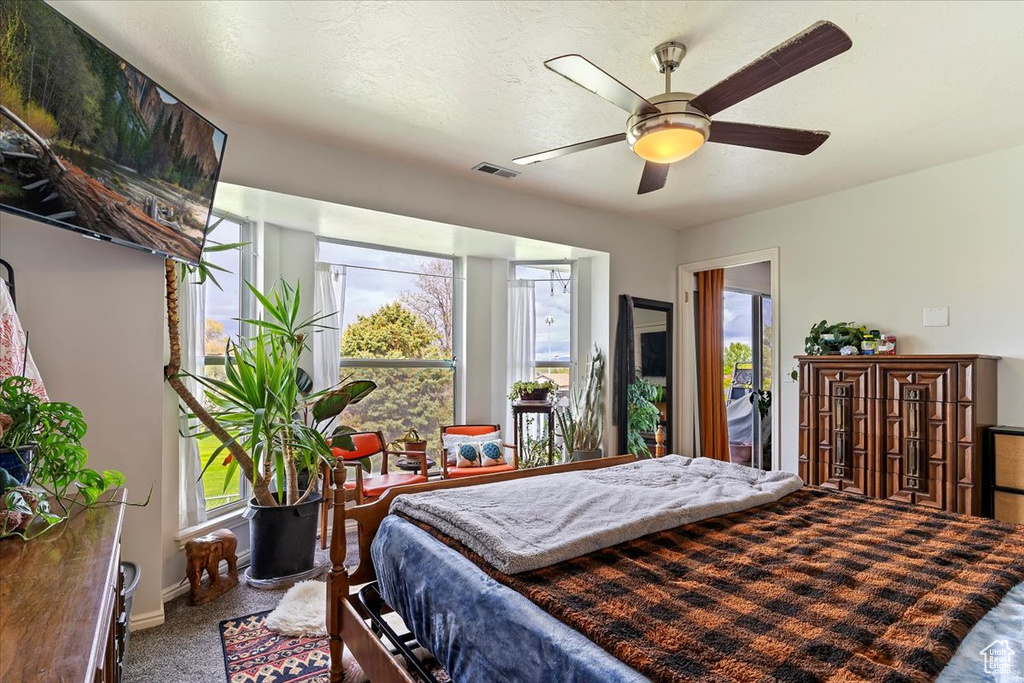 Bedroom featuring a ceiling fan, carpet flooring, and visible vents