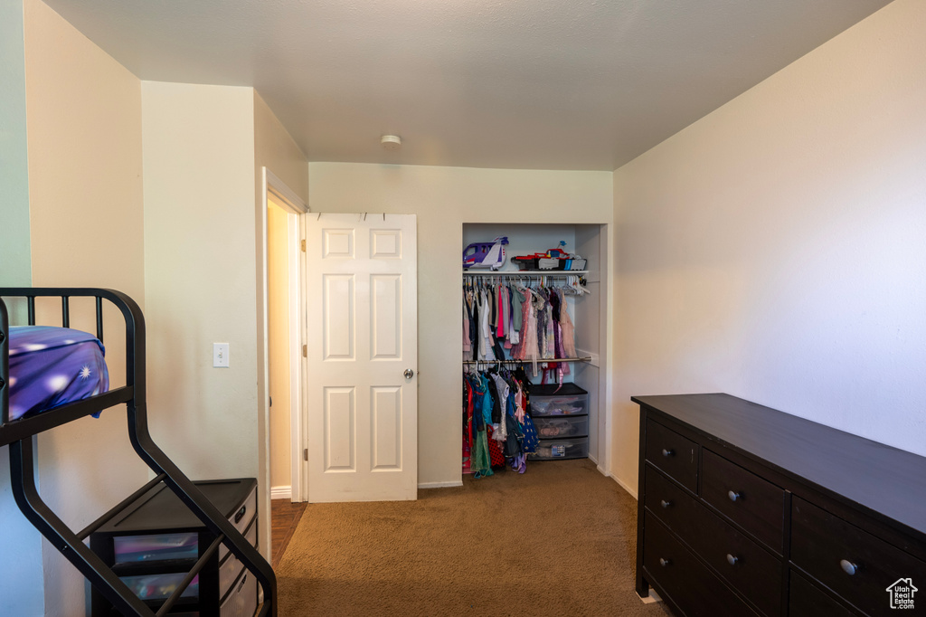 Carpeted bedroom with a closet
