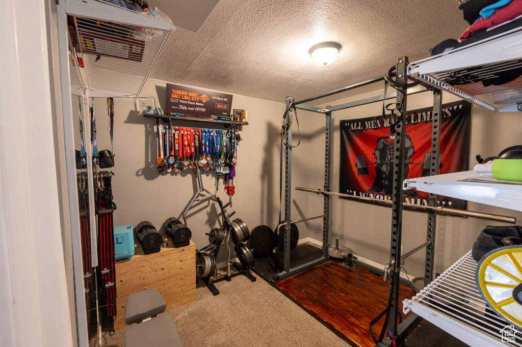 Exercise area featuring carpet and a textured ceiling