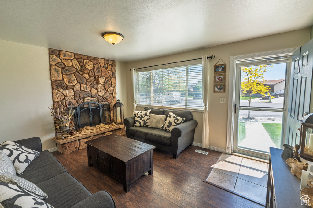 Living room featuring baseboards, a fireplace, wood finished floors, and visible vents