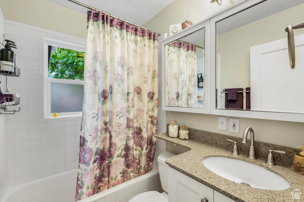 Bathroom with vanity, toilet, and shower / tub combo