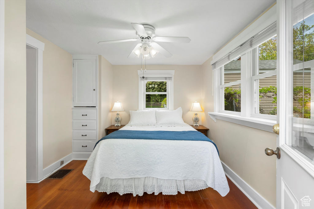 Bedroom featuring baseboards, a ceiling fan, wood finished floors, and visible vents