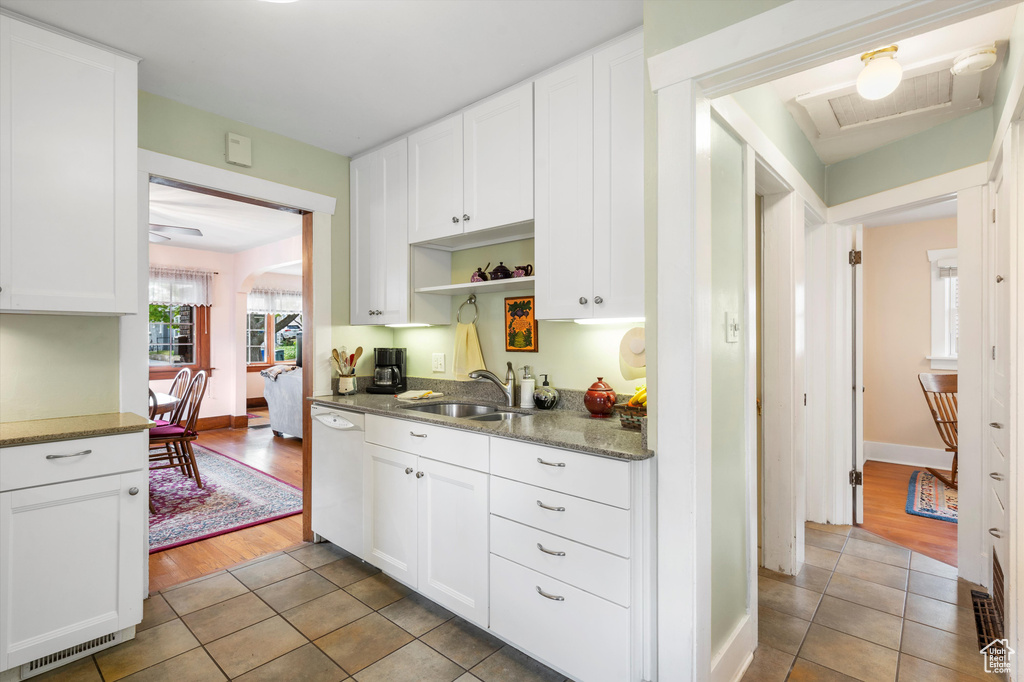 Kitchen with a sink, open shelves, dishwasher, and tile patterned floors