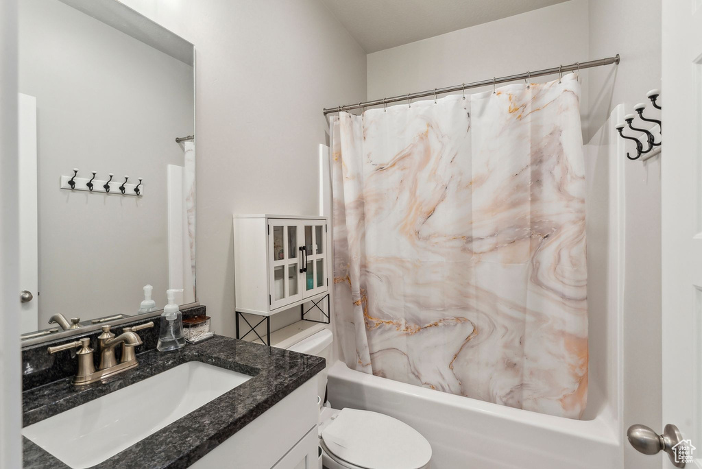 Full bath featuring vanity, toilet, and shower / tub combo