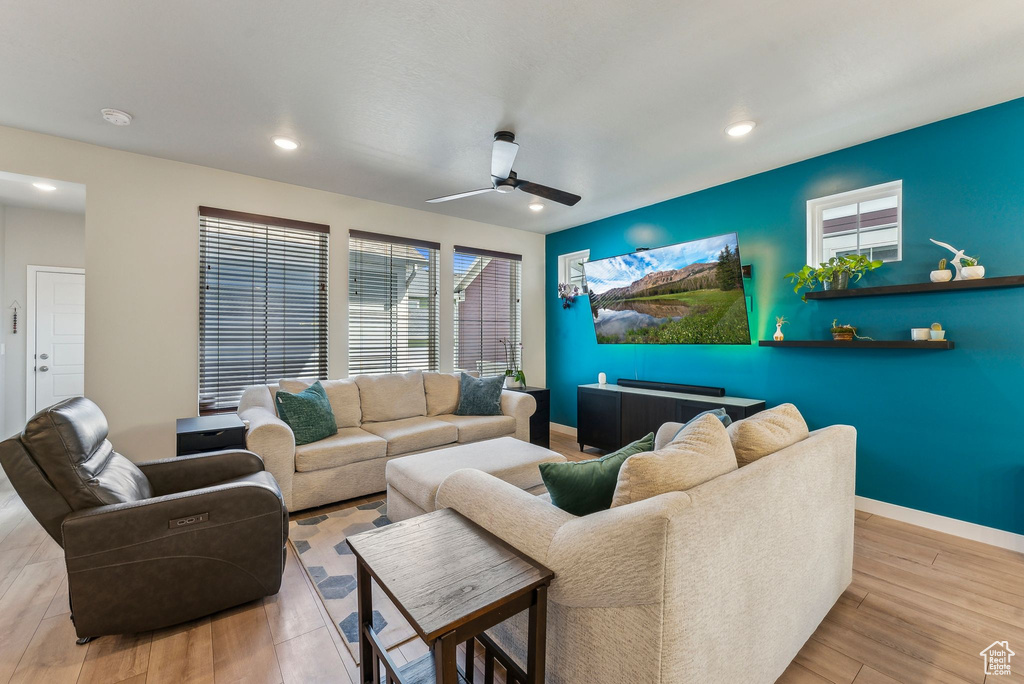 Living room with baseboards, ceiling fan, and wood finished floors