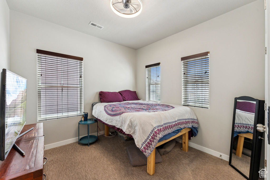 Carpeted bedroom featuring visible vents and baseboards